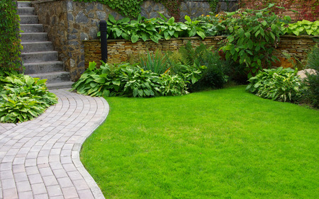 Garden stone path with grass growing up between the stones