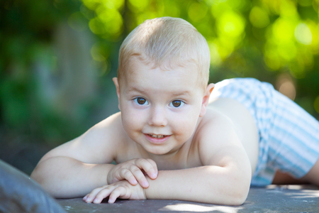 Happiness Baby boy sitting in the garden. Portrait of young boy in natureの写真素材