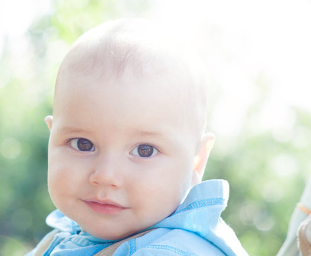 Happiness Baby boy sitting on green grass on sunny summer dayの写真素材