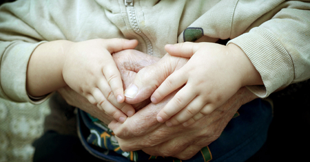 Old hand holding and young holding hands の写真素材