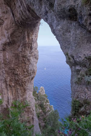 The natural arch in Capri, Italy. A view looking back to the elephant shaped, natural arch from the coastal path on the island of Capri.の写真素材