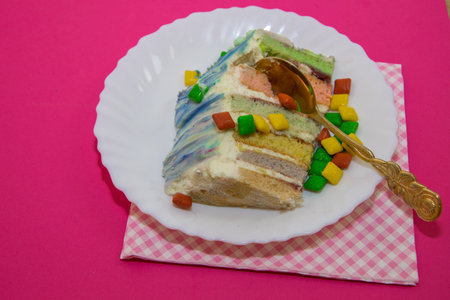 colored cut cake on a raspberry backgroundの写真素材