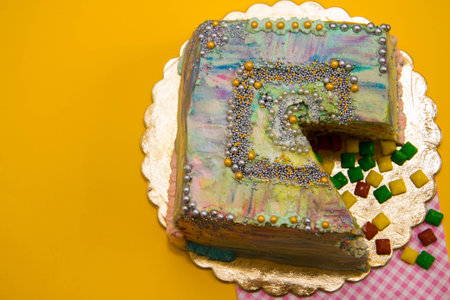colored cut cake on a yellow background, decoratedの写真素材