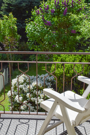 armchair on the balcony in front of the gardenの写真素材