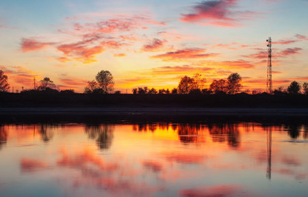 Dramatic sunset over the river. Beautiful view of the evening sky