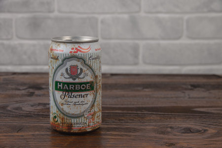 An old aluminum can of Harboe Denmark beer against the brick wall