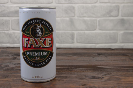 An old aluminum can of Faxe beer against the brick wall