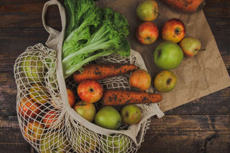 Flat lay composition with meshed eco bag. Fruits and vegetables in cotton bag. Vegan, zero waste, plastic free conceptの写真素材