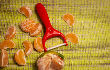 The vegetable cutter lies next to the tangerine slicesの写真素材