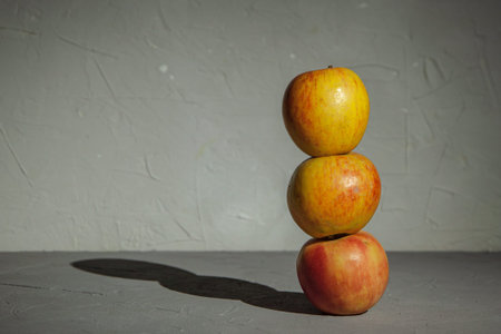 Three ripe apples are stacked on top of each other in the form of a tower