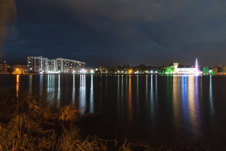 Colorful lights from building reflects on the lake water surface at nightの写真素材