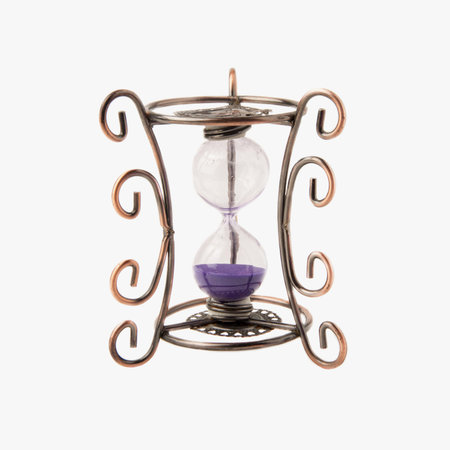 Vintage hourglass with purple sand isolated on white background. Close up