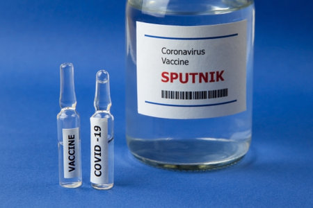 Krasnodar, Russia - January 12, 2021: Two ampoules and a bottle of Sputnik vaccine from Covid-19 on a blue backgroundのeditorial素材