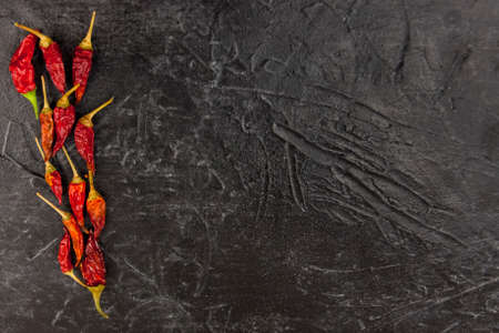 Hot red chili pepper dry lies on a black background Top view and empty space for textの写真素材