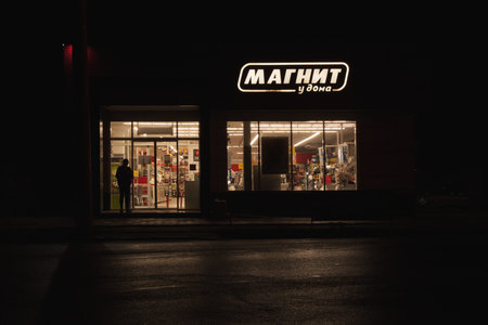 Supermarket Magnet at night before closing. The sign and trading floor are lit up
