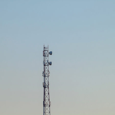 A cell tower outside the city against a dirty blue sky