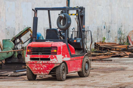 Diesel red battered forklift truck on the street against the background of scrap metal. Close-upの写真素材