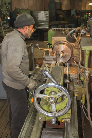 Krasnodar, Russia - October 10, 2011: The turner processes the part on a lathe