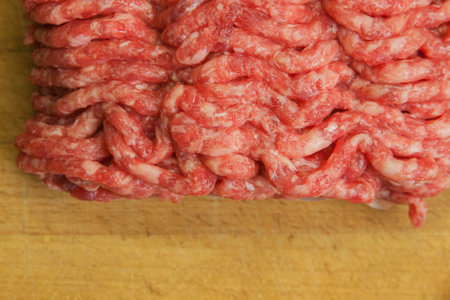 Fresh minced beef on the background of the kitchen board. Empty space for the text. Top view