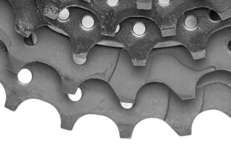 The teeth of the bicycle cassette are black in close-up on a white background. Background image
