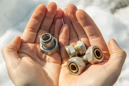 In the men's open palms are fittings for reinforced plastic pipes. Selective focus. Close-upの写真素材