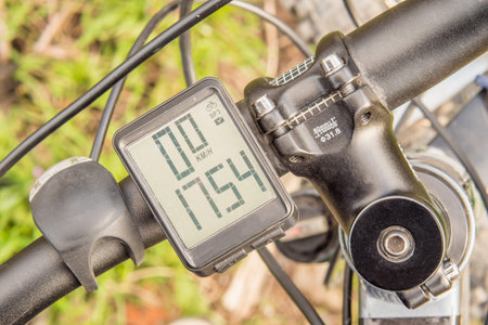 Black mountain bike handlebar with wireless bike computer close-up. Top view