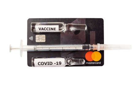 Krasnodar, Krasnodar Territory, Russia, Jule 5, 2021: Close-up of a black mastercard bank card with a syringe and two ampoules of vaccine. The concept of purchasing a vaccine for any moneyのeditorial素材
