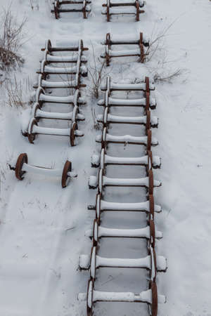 Rusty snow-covered carriage pairs on the tracks of the railway station. The concept of railway transportationの写真素材