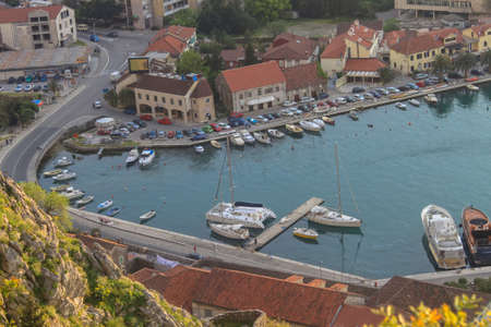 View from above of the bay with boats and yachts, as well as the road and stone houses with shingles. The concept of tourism in Montenegro. Montenegro, Kotor, April 21, 2013のeditorial素材