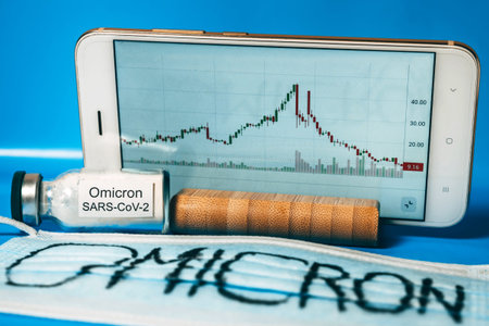 A smartphone with a falling stock exchange chart, a medical mask with the inscription Omicron and an...