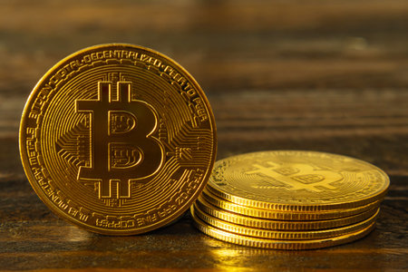 BTC gold coins on a dark wooden background. bitcoin cryptocurrency. One coin standing and 5 more...