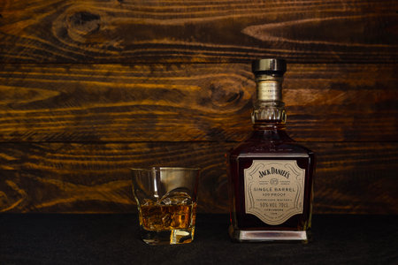 Bottle of Jack Daniels Single Barrel American Whiskey and a glass with ice on a dark wooden background. Single Barrel whiskey belongs to the super-premium category. Russia, Krasnodar, December 11, 2021のeditorial素材