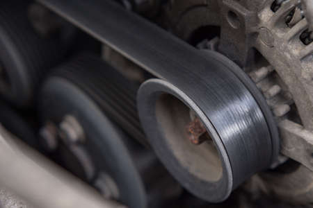 Close-up of the drive belt and the alternator roller in the car engine. Dirty motorの写真素材