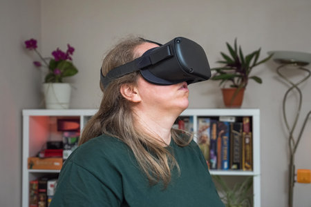 Close-up of a girl in a virtual reality helmet in a gray room against a rack of board games and...