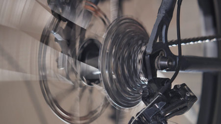 Rotating mountain bike drivetrain, brake disc and spokes. Close-up view. Side view Repair and...