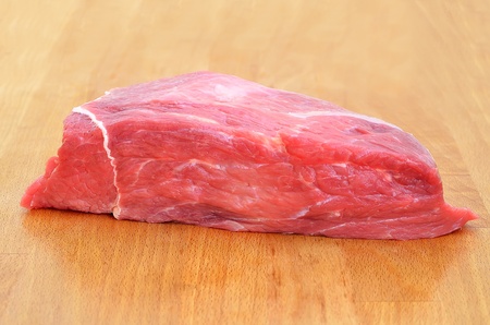 A piece of meat on a wooden tableの写真素材