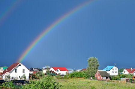 Rainbow over the houses in the countrysideのeditorial素材