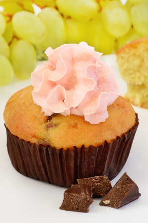 Muffin decorated with cream and chocolate piecesの写真素材