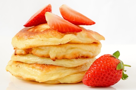 Homemade cheese pancakes and strawberries on a white plateの写真素材