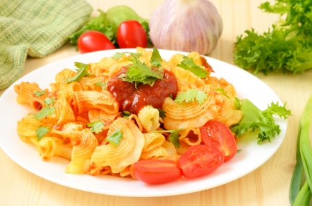 Pasta with tomato sauce on white plate on the wooden tableの写真素材