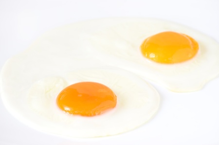 Fried eggs on a white plateの写真素材