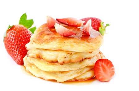 Homemade cheese pancakes and strawberries on a white backgroundの写真素材