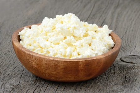 Cottage cheese in the bowl on the wooden garden tableの写真素材
