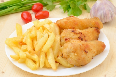 Fried chicken with french fries on wooden tableの写真素材