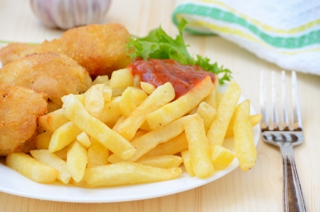 Fried chicken with french fries on wooden tableの写真素材