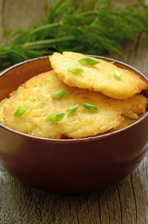 Potato pancakes in brown ceramic bowl on wooden tableの写真素材