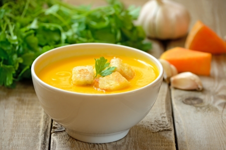 Pumpkin soup with croutons on wooden tableの写真素材