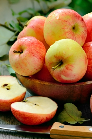Red ripe apples in bowl on a wooden tableの写真素材