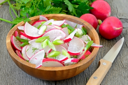 Radish salad in bowl on wooden tableの写真素材