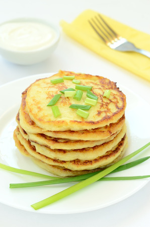 Potato pancakes with green onion on white plateの写真素材